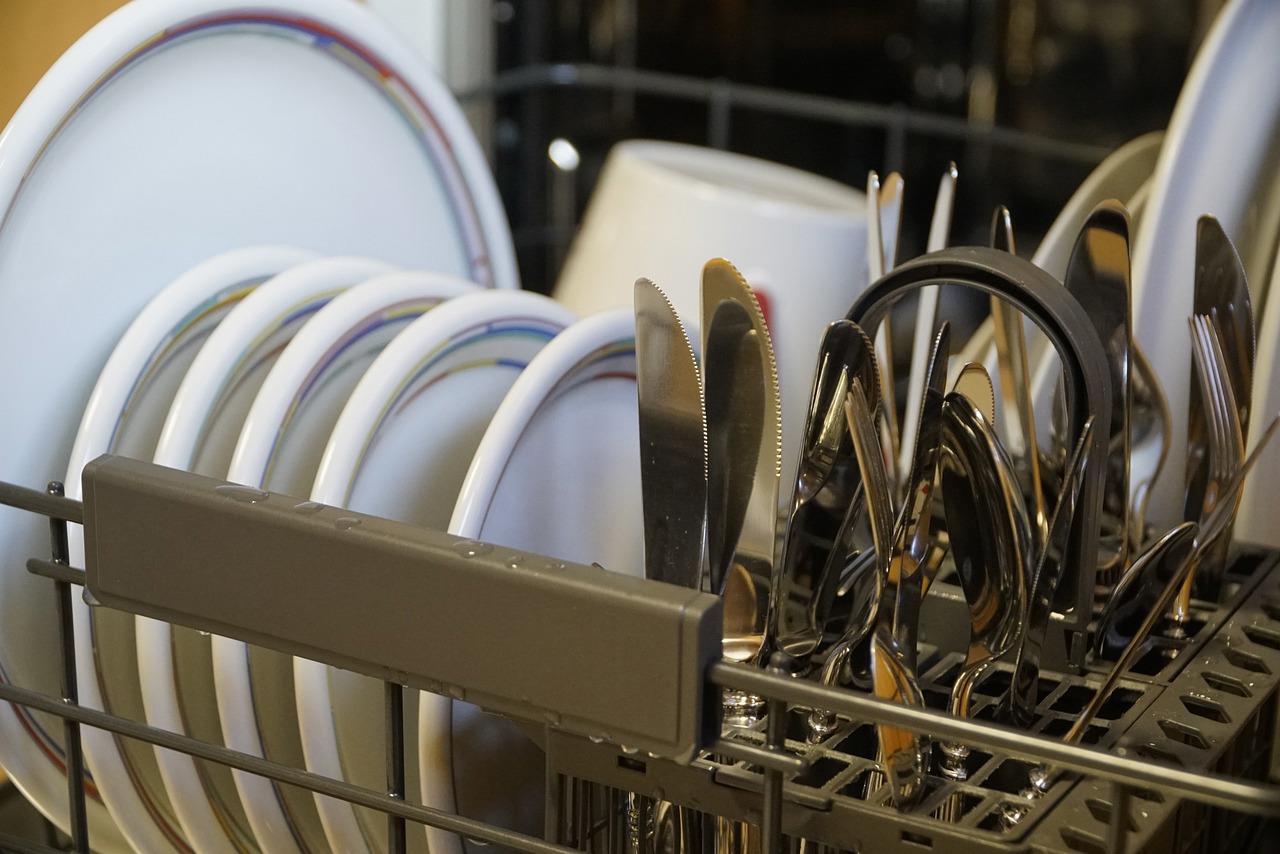 a dishwasher filled with plates knives and silverware