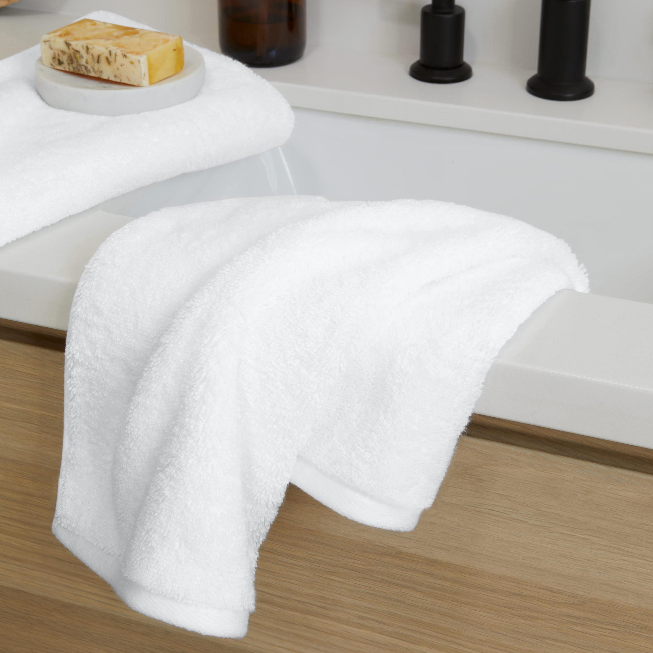 a white towel is sitting on a counter next to a soap dish