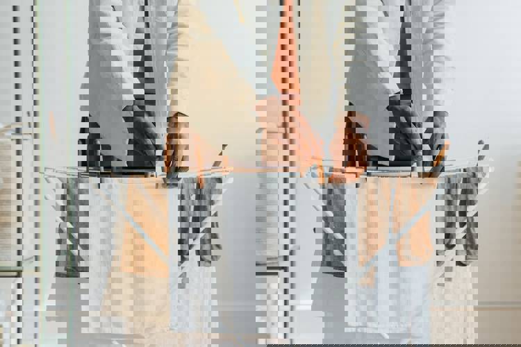 a person is hanging clothes on a drying rack