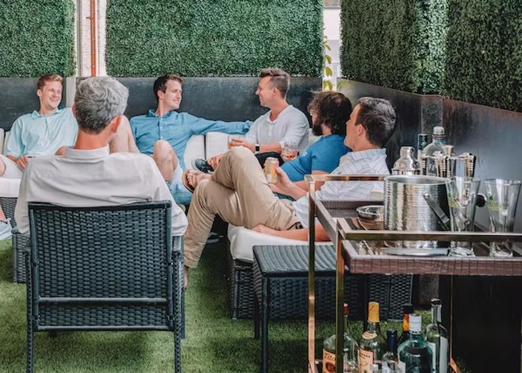 a group of men are sitting in chairs on a patio