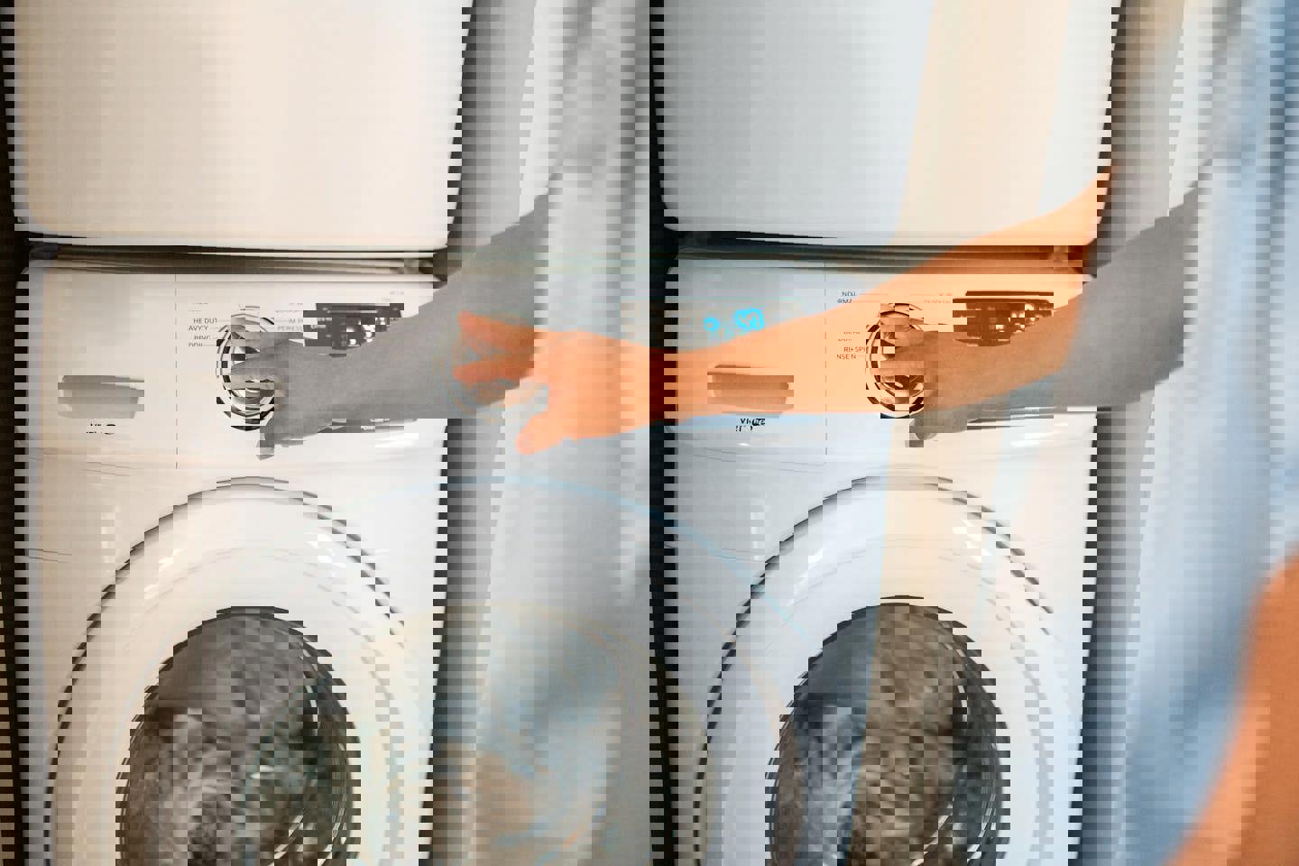 a person is pressing a button on a washing machine