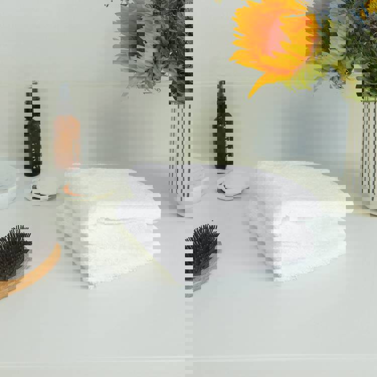 a white towel is sitting on a counter next to a vase of sunflowers