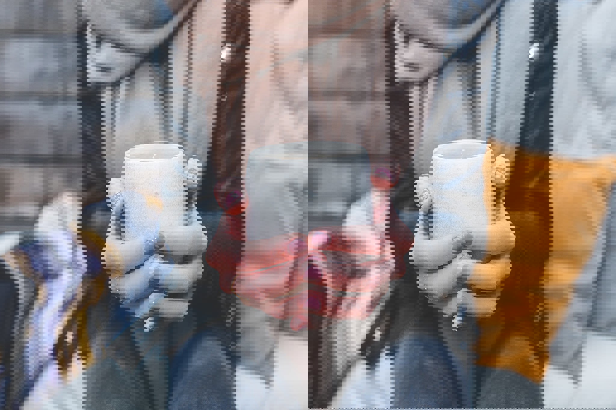 a woman is holding a cup of coffee in her hands