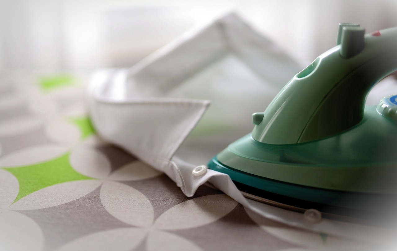 a white shirt is being ironed by a green iron