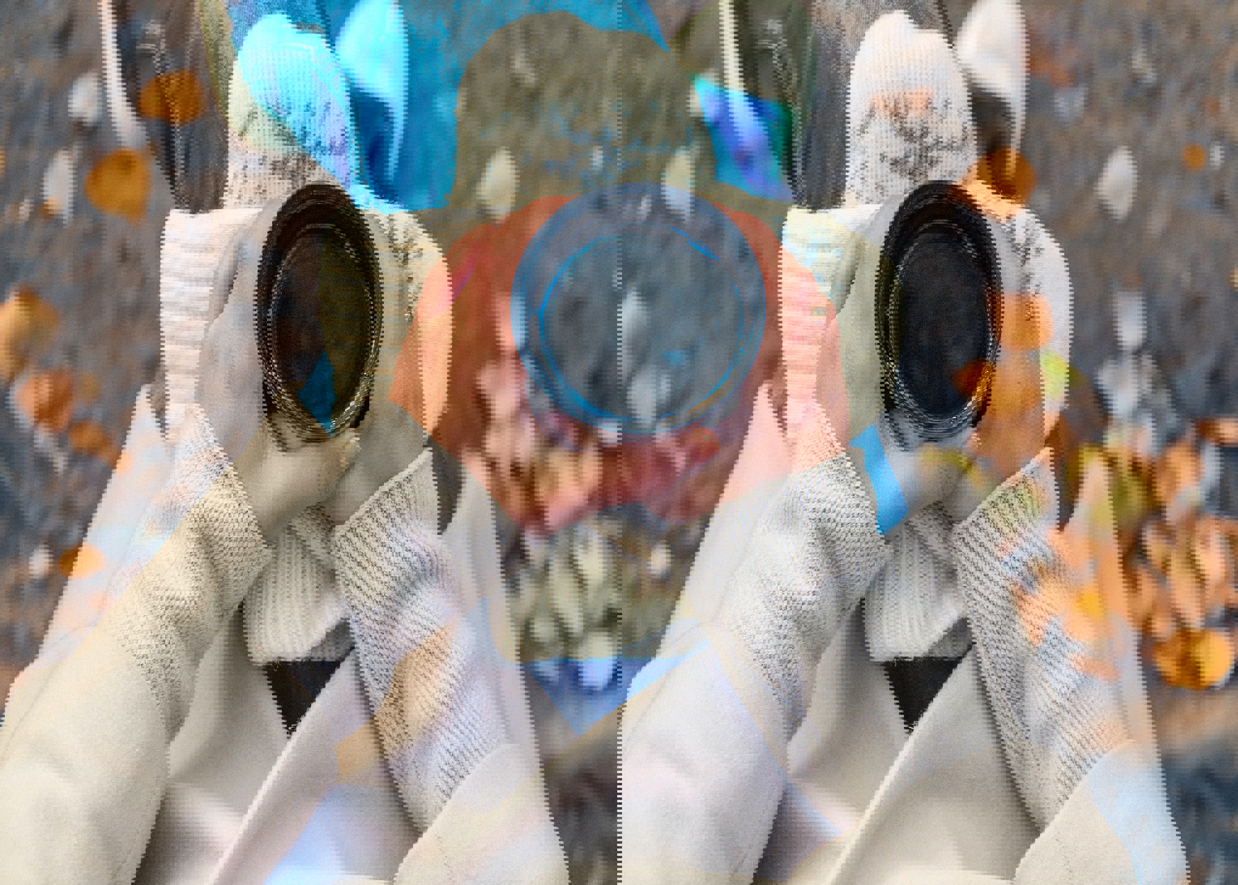 a person wearing mittens holds a cup of coffee