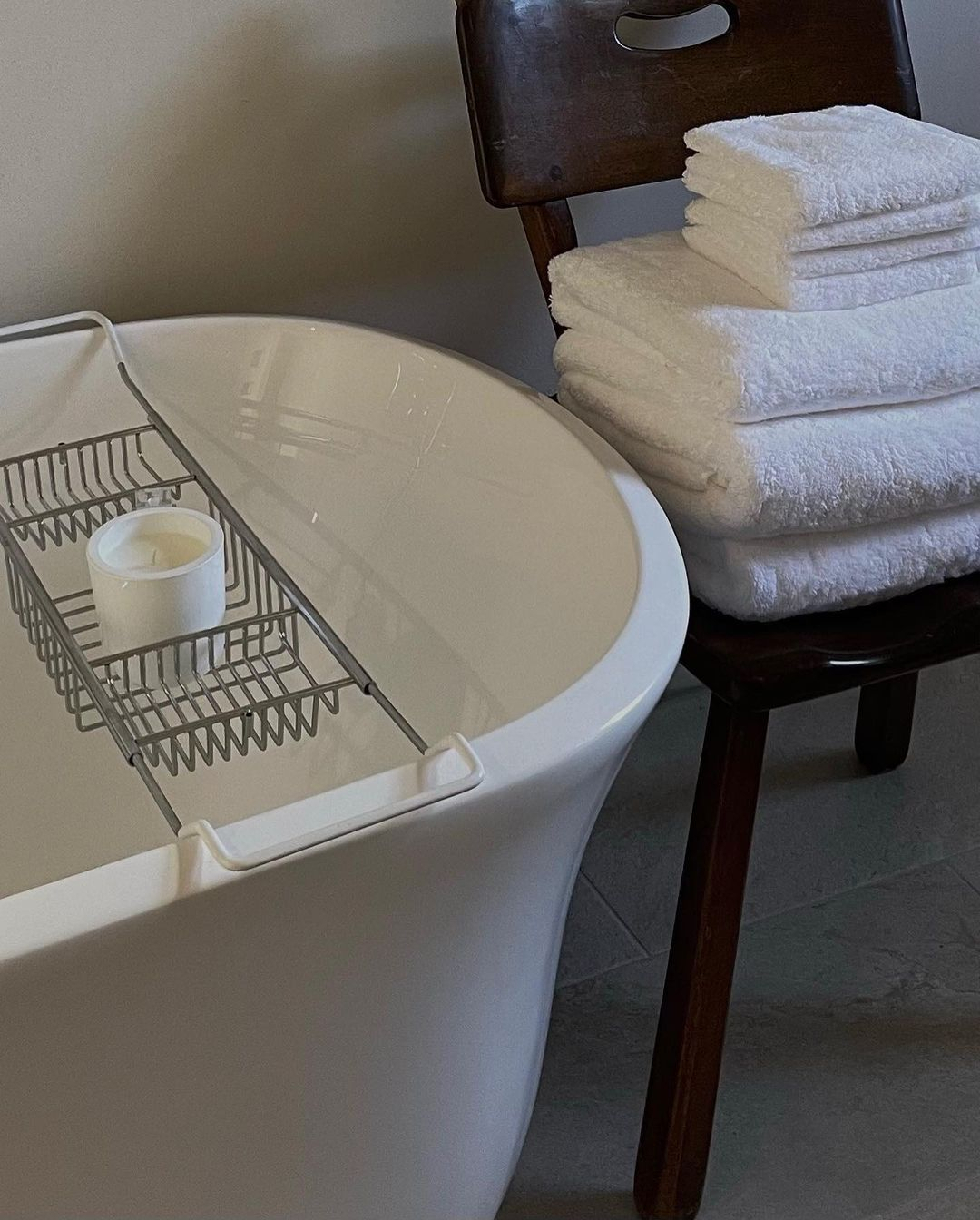 a bathtub with a candle and towels on the side