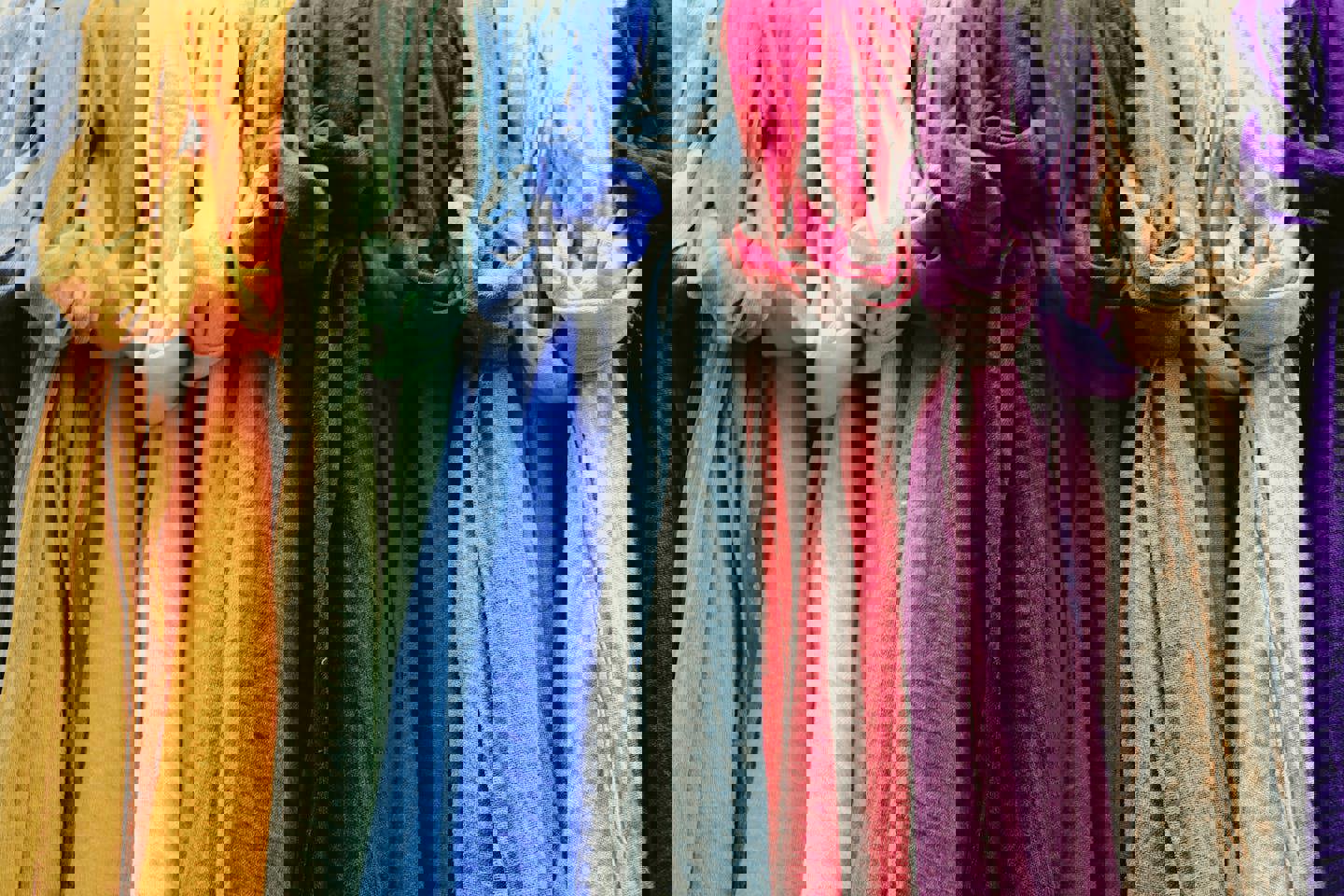 a row of colorful scarves hanging on a rack