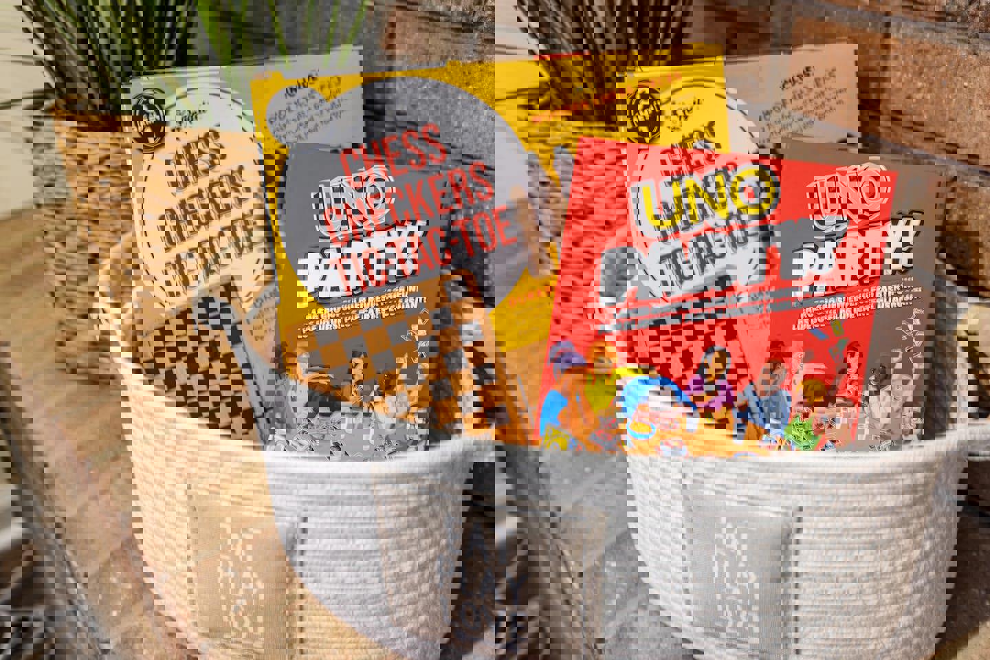 a basket filled with chess checkers tic tac toe and uno party