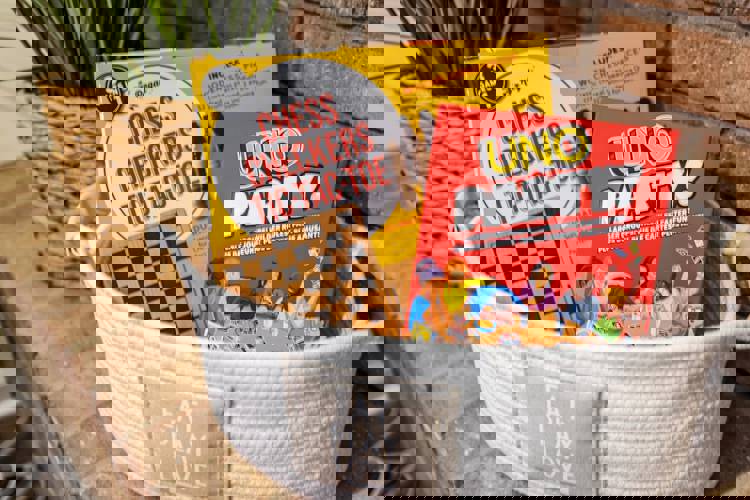 a basket filled with chess checkers tic tac toe and uno party