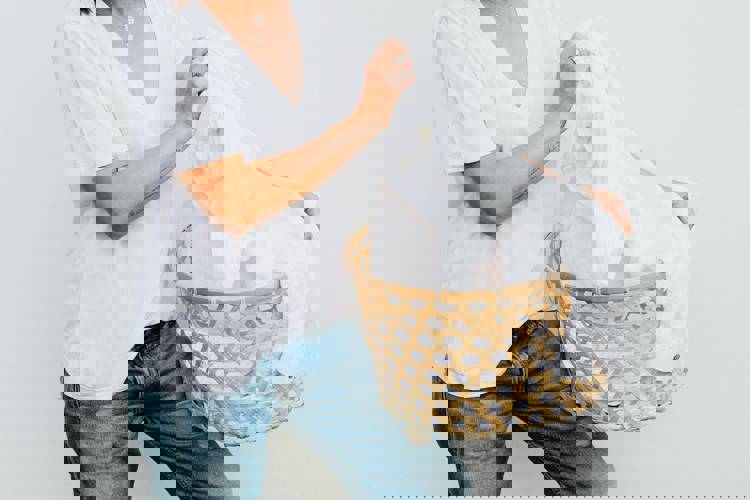 a woman is holding a laundry basket full of white clothes