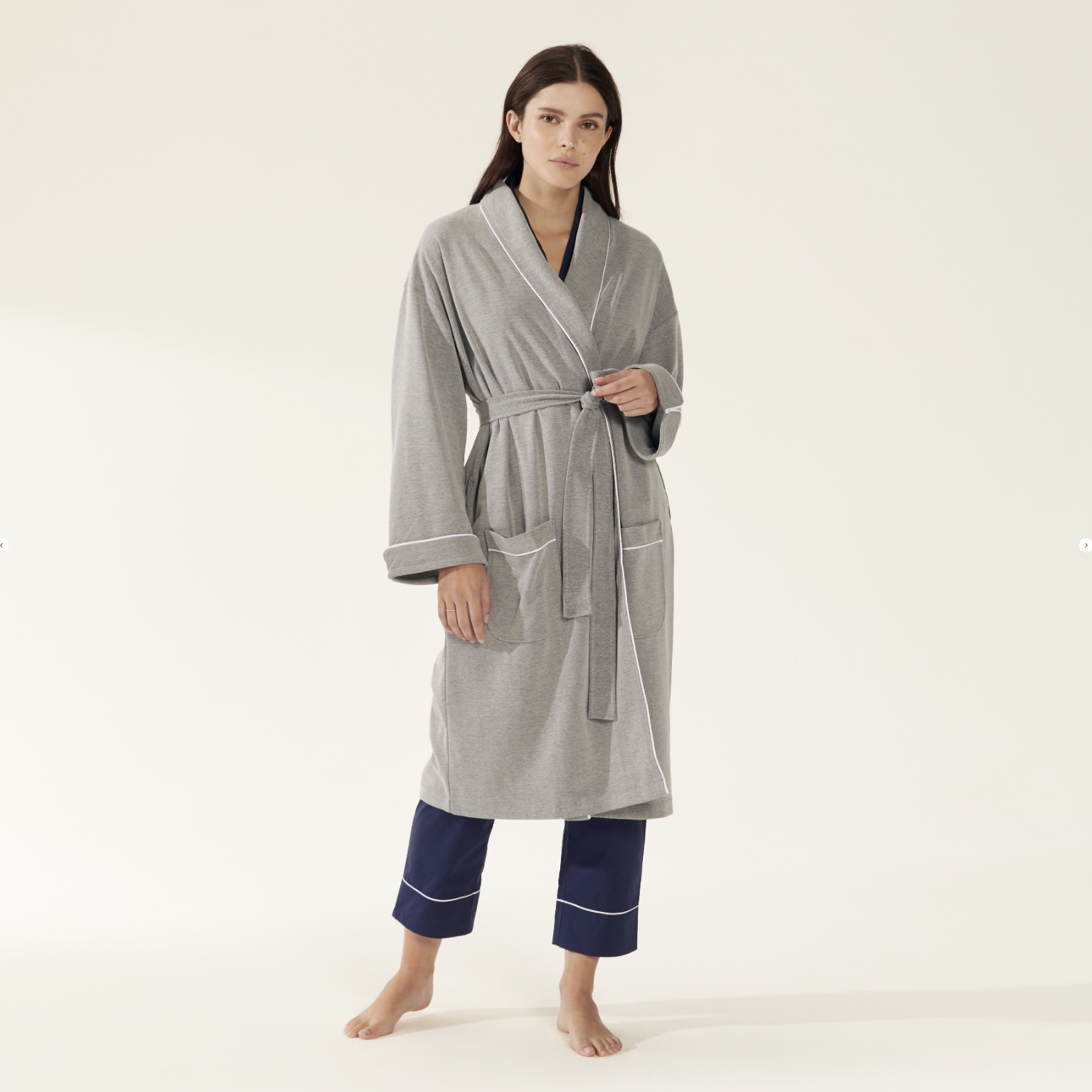 a woman is wearing a grey robe and blue pants