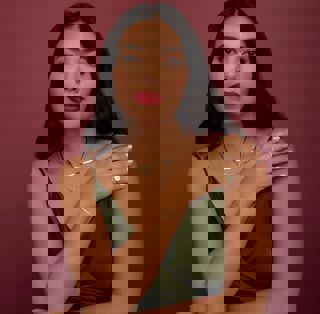 a woman in a green dress is wearing a necklace and bracelet