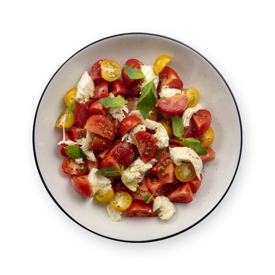 a white bowl filled with tomatoes , mozzarella and basil on a black background