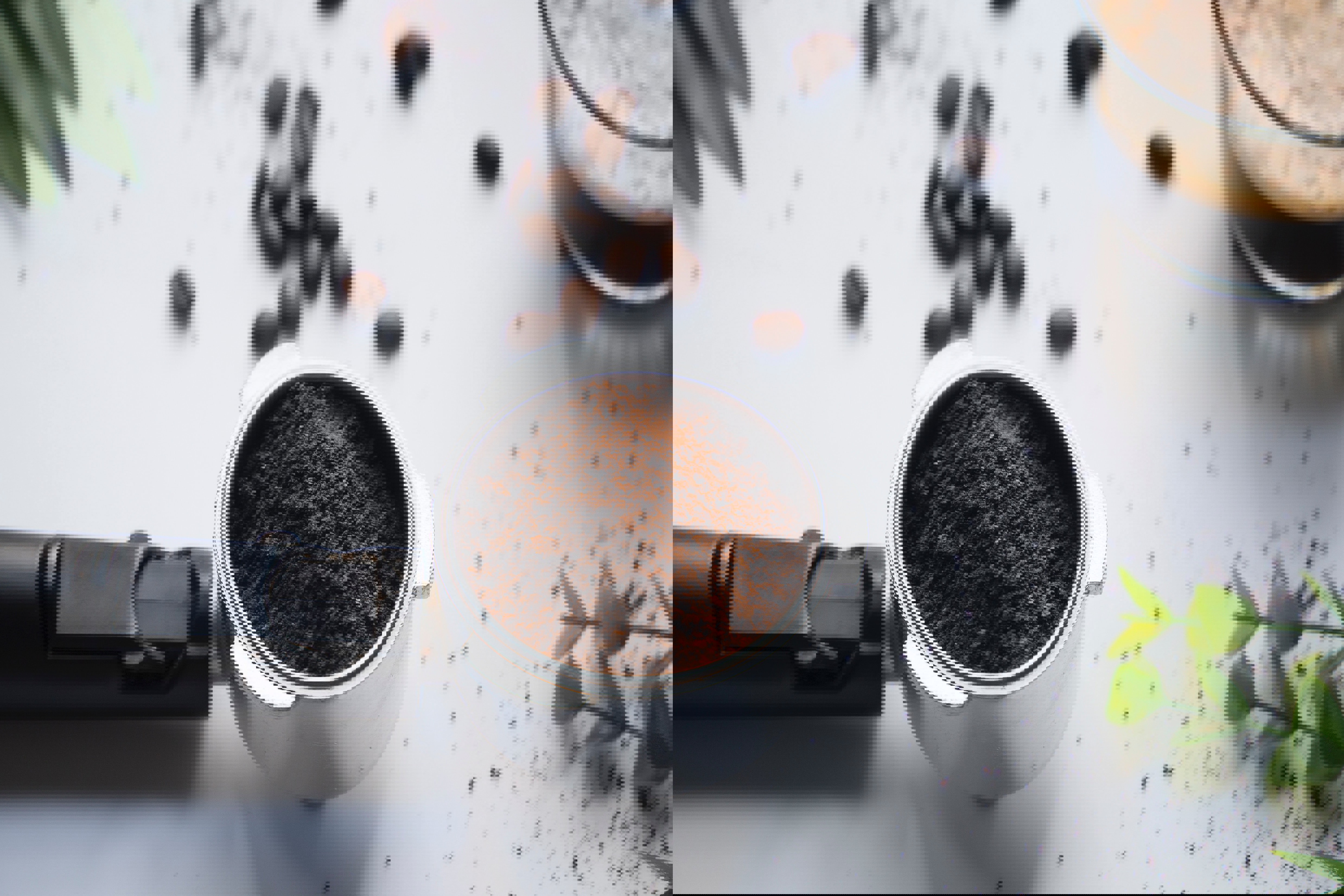 a cup of ground coffee sits on a table next to coffee beans