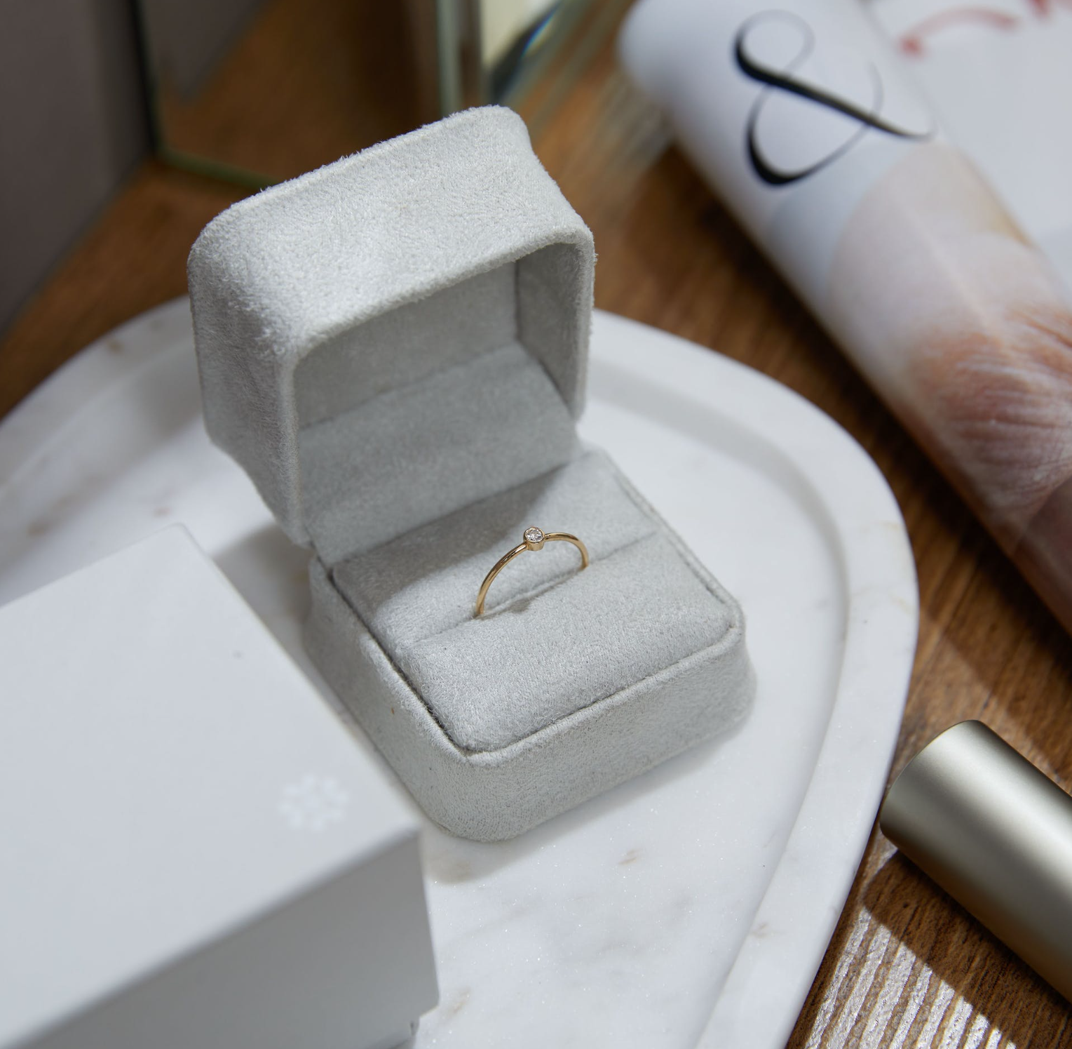 a ring is in a box on a table next to a magazine