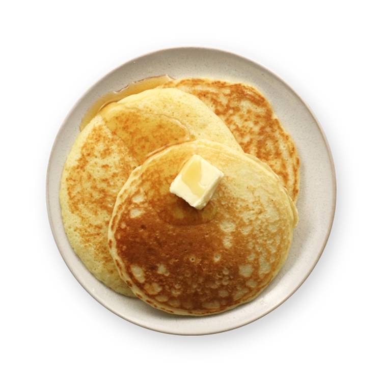 a plate of pancakes with syrup and butter on a black background