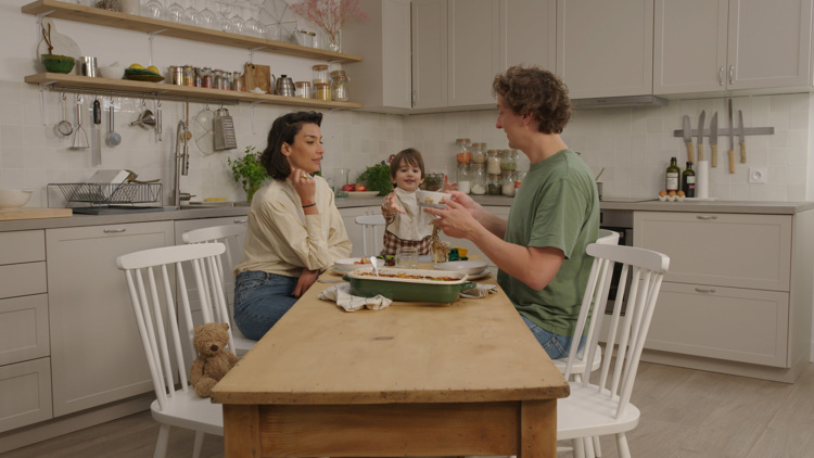 a man and a woman sit at a table with a child in a bib