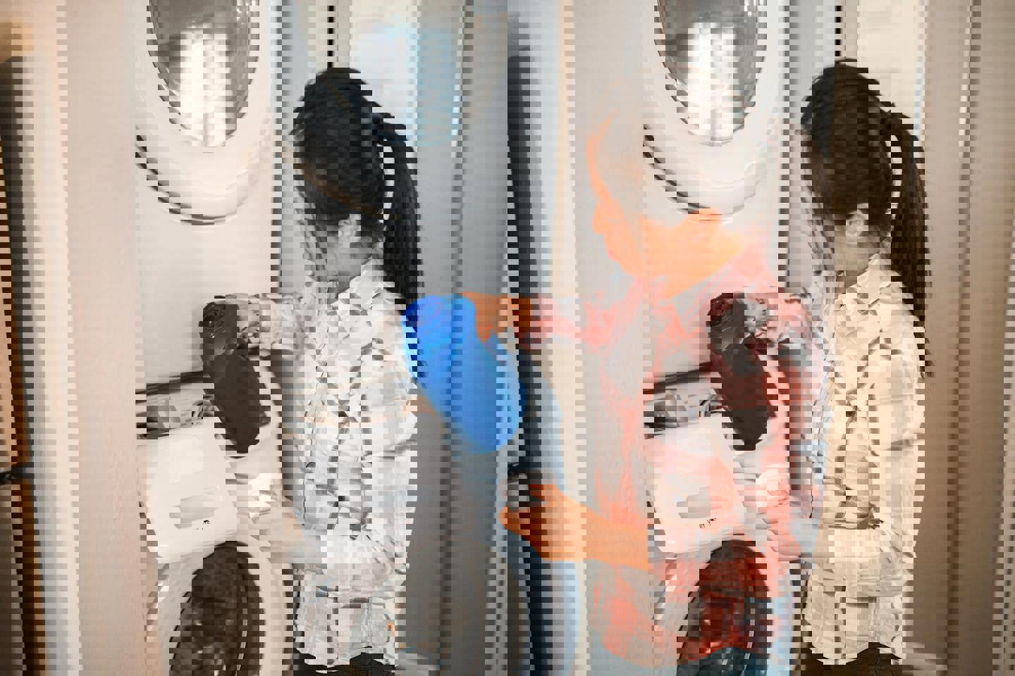 a woman is pouring laundry detergent into a washing machine