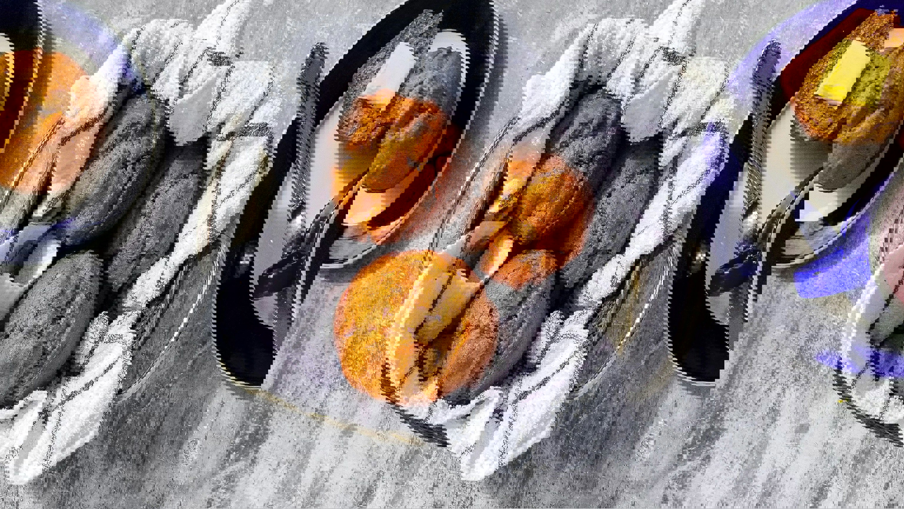 a basket of muffins sits on a table next to a cup of tea