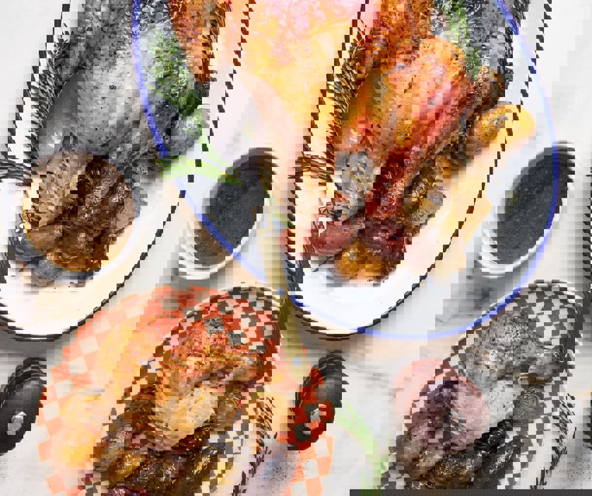 a roasted chicken with potatoes and brussels sprouts on a checkered plate