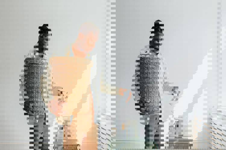 a man is holding a wicker basket and pouring liquid into it