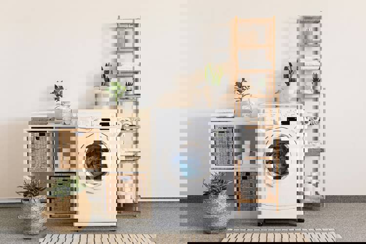 a white washing machine is sitting in a laundry room