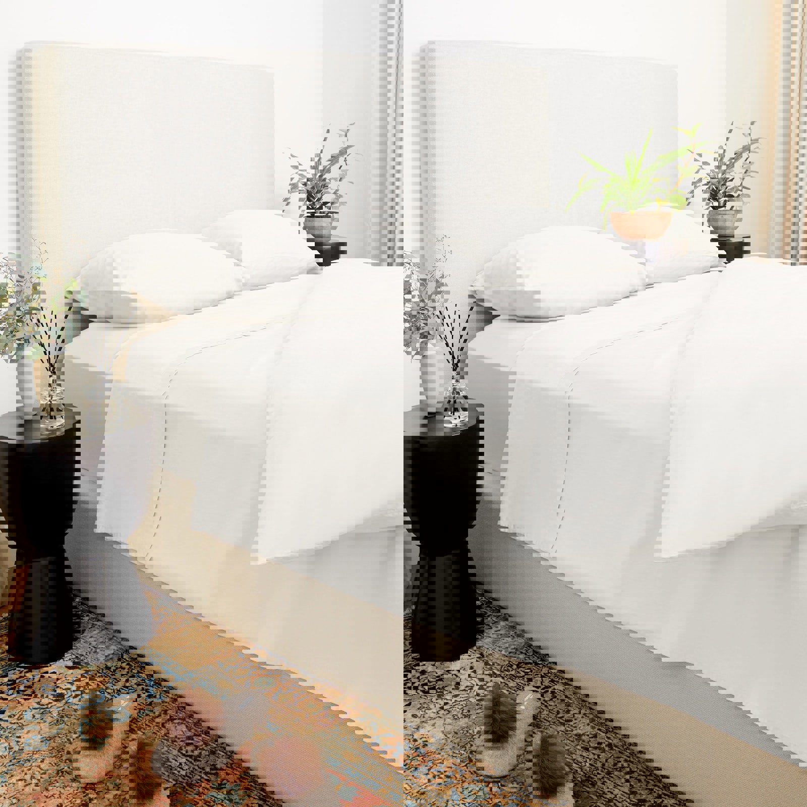 a bed with white sheets and pillows in a bedroom