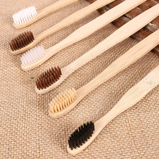 a row of bamboo toothbrushes with different colored bristles