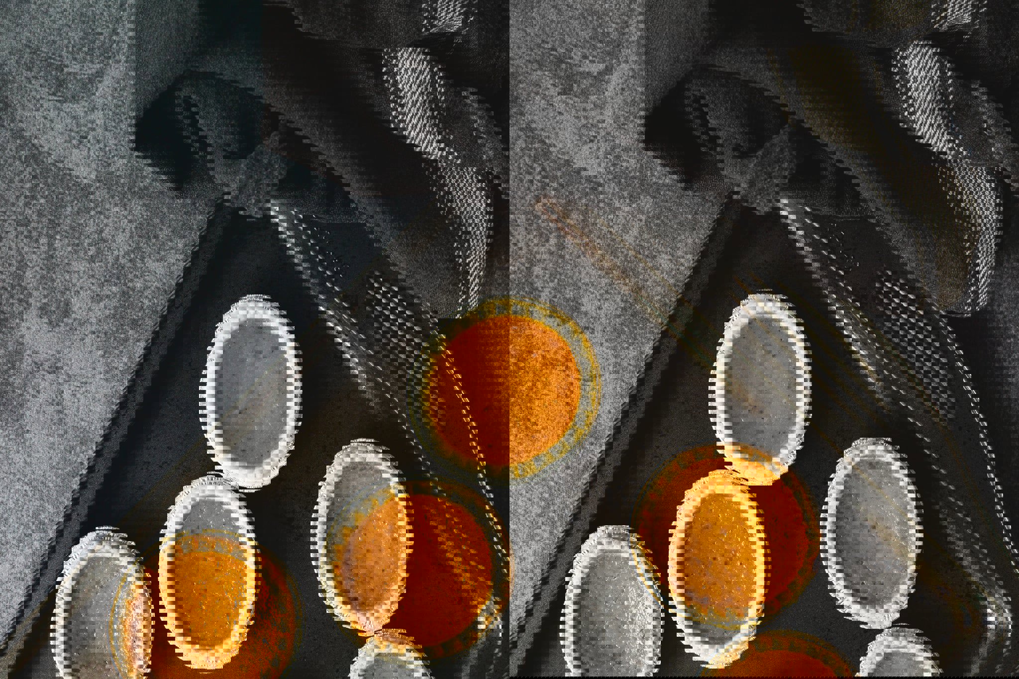 a tray of mini pumpkin pies with a fork