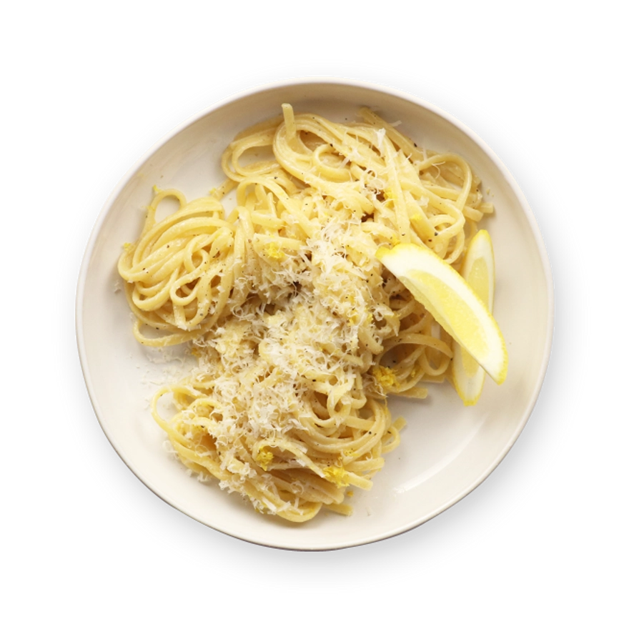 a white plate topped with noodles and a slice of lemon