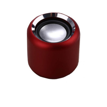 a red speaker with a silver rim sits on a white surface