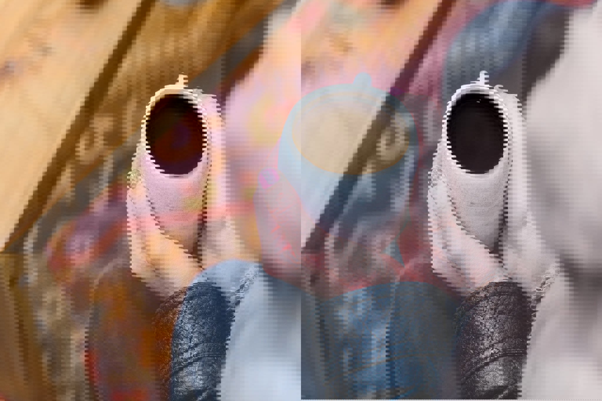 a woman is holding a cup of coffee in her hands