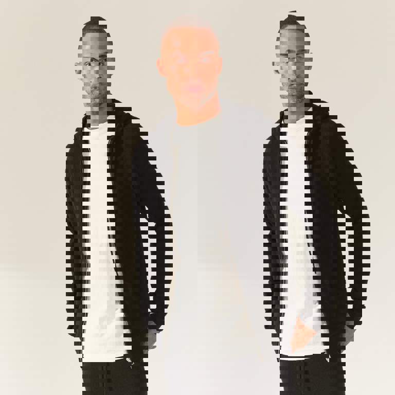 a man wearing a black hoodie and a white shirt