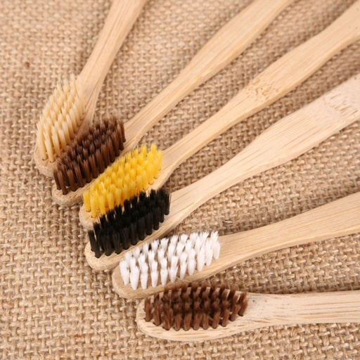 a group of bamboo toothbrushes with different colored bristles
