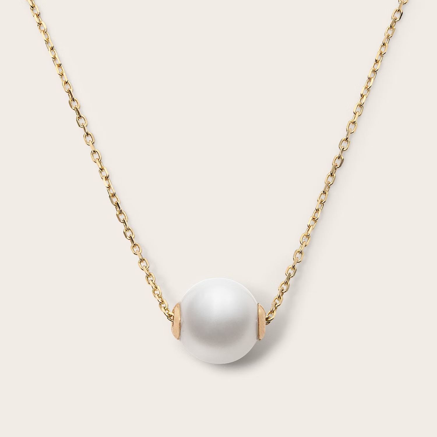 a necklace with a single white pearl on a gold chain