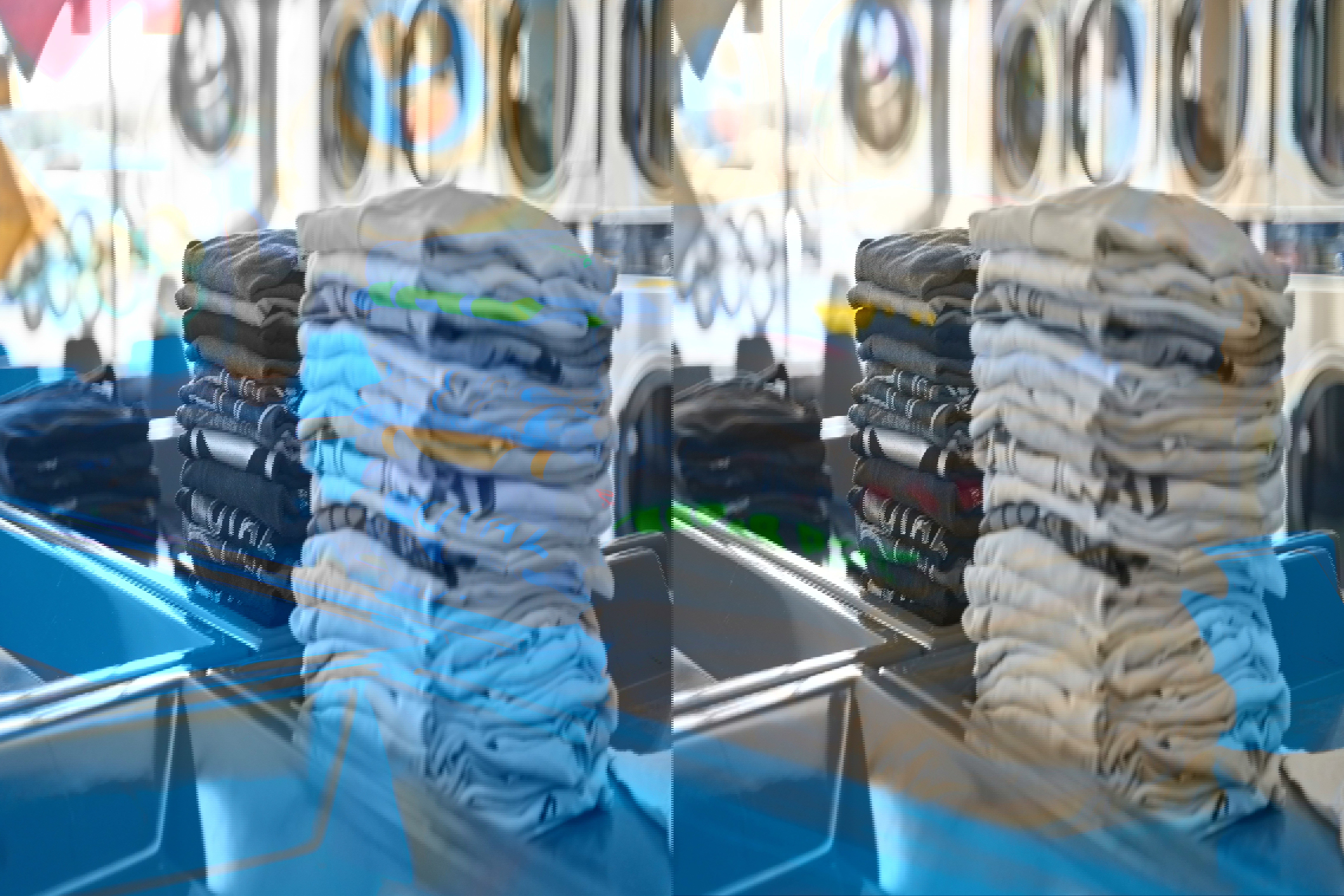 a stack of t-shirts in a laundromat with one that says ' ucla ' on it