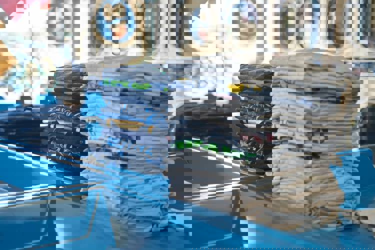 a stack of t-shirts in a laundromat with one that says ' ucla ' on it