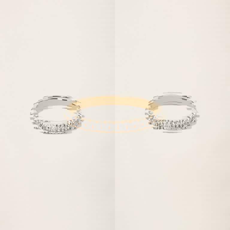 a yellow gold ring with diamonds on a white background