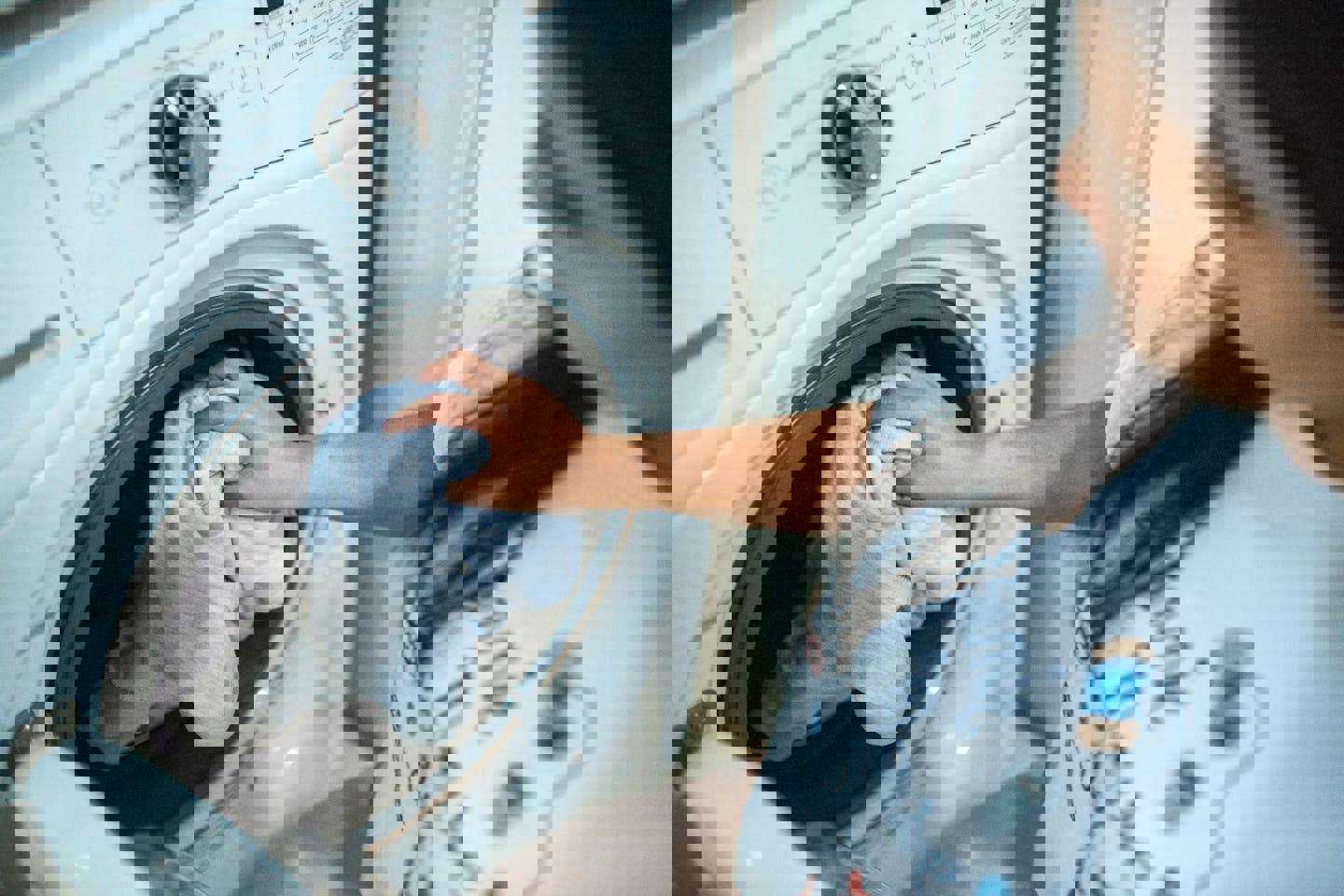 a woman is putting clothes into a washing machine