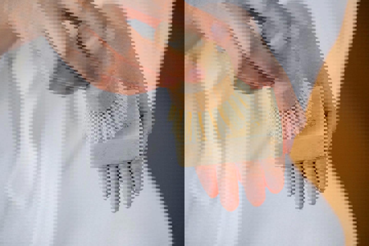 a person is holding a bar of soap and a brush in their hand