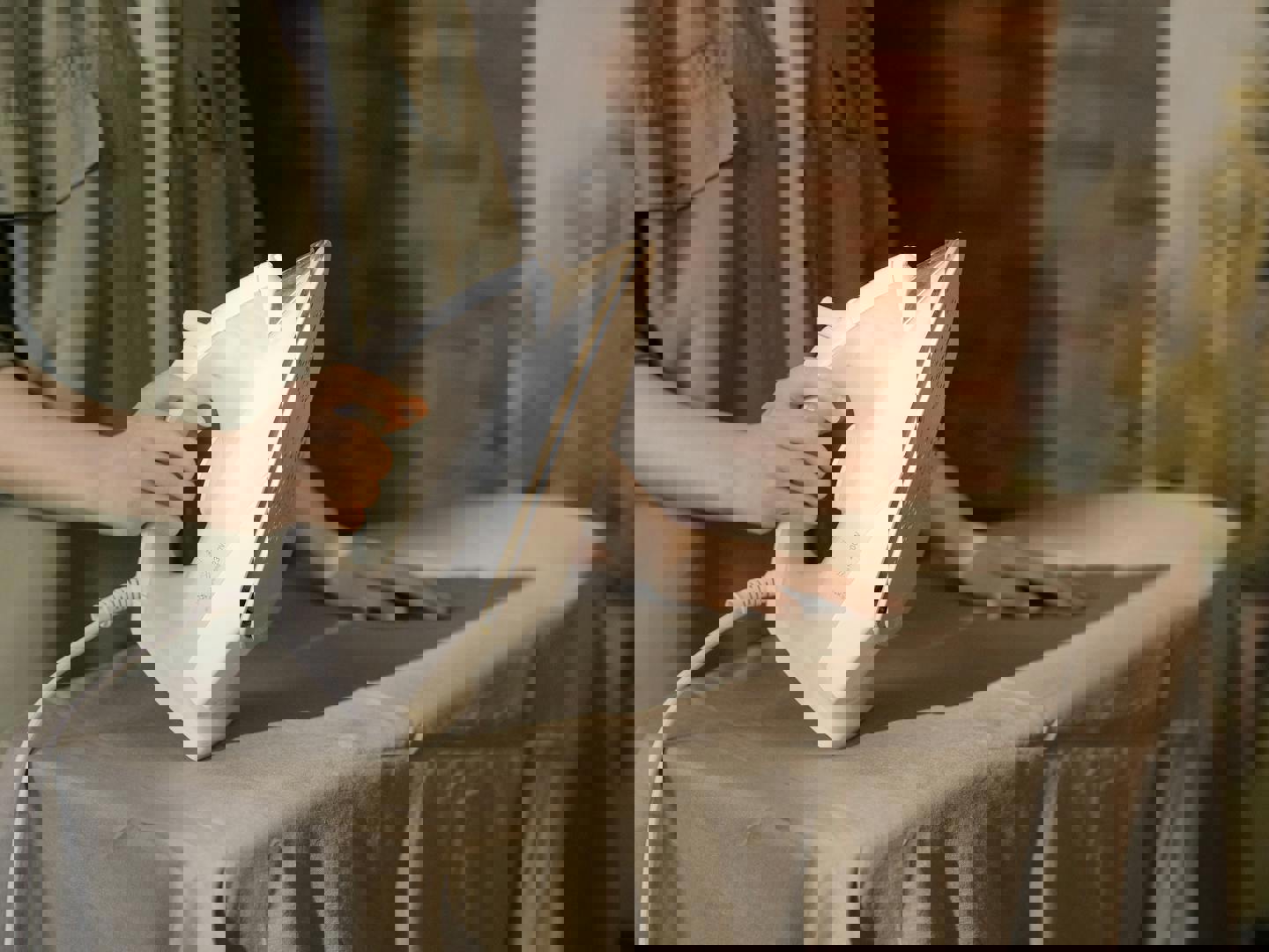 a person is ironing a piece of cloth on an ironing board