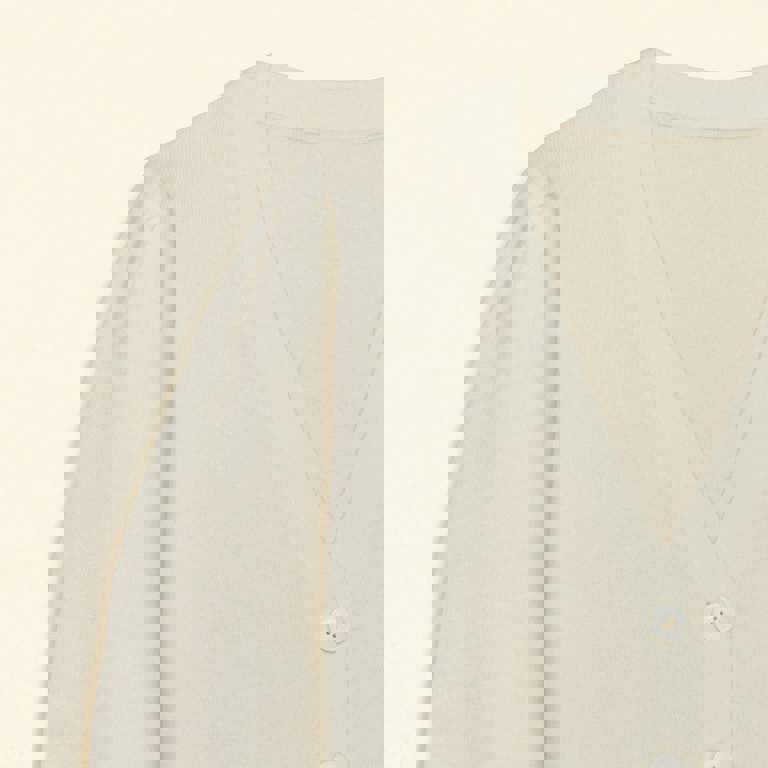 a close up of a white cardigan with white buttons
