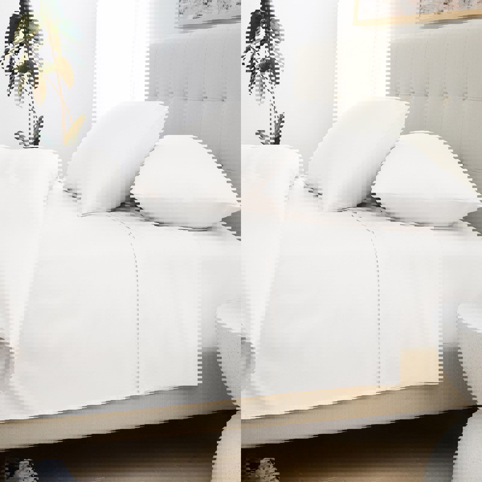 a bed with white sheets and pillows in a bedroom