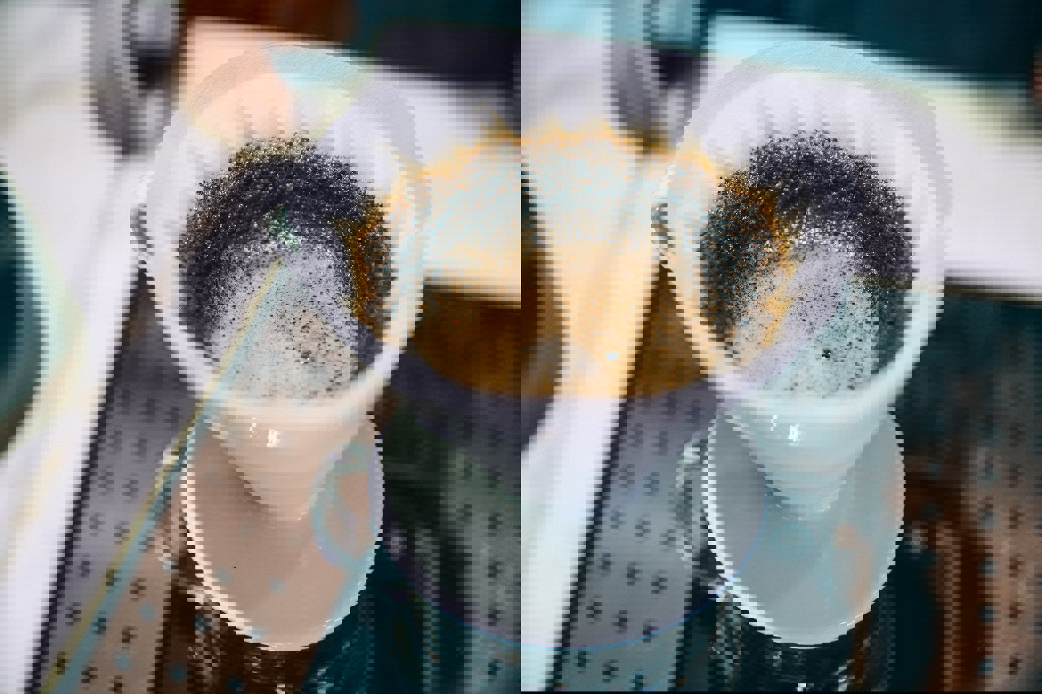 a cup of coffee is being poured through a paper filter