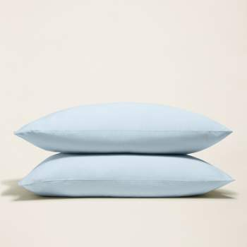 two light blue pillows are stacked on top of each other