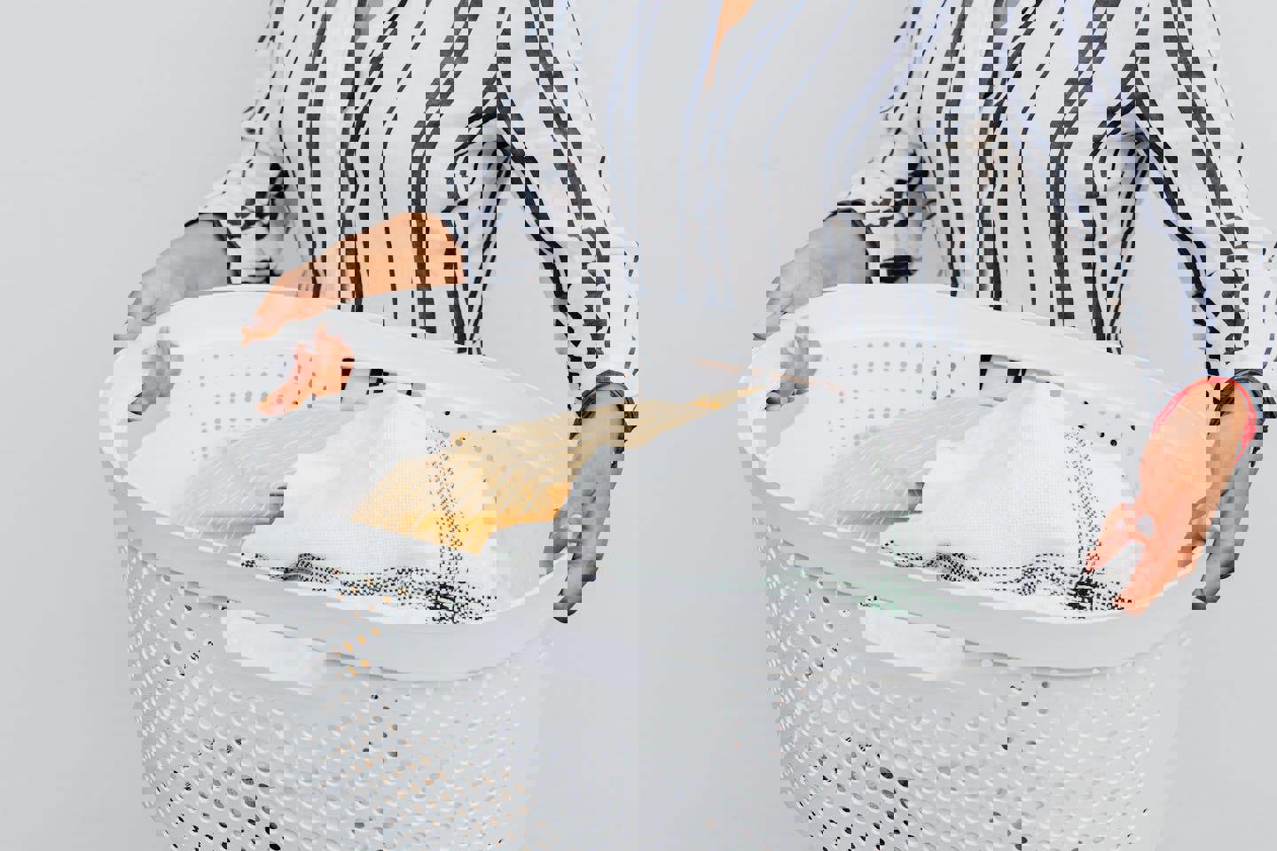 a woman is holding a laundry basket full of clothes