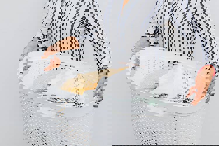 a woman is holding a laundry basket full of clothes