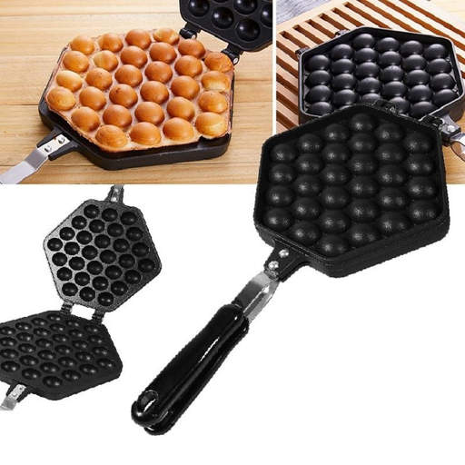 a waffle maker with eggs in it is sitting on a wooden table