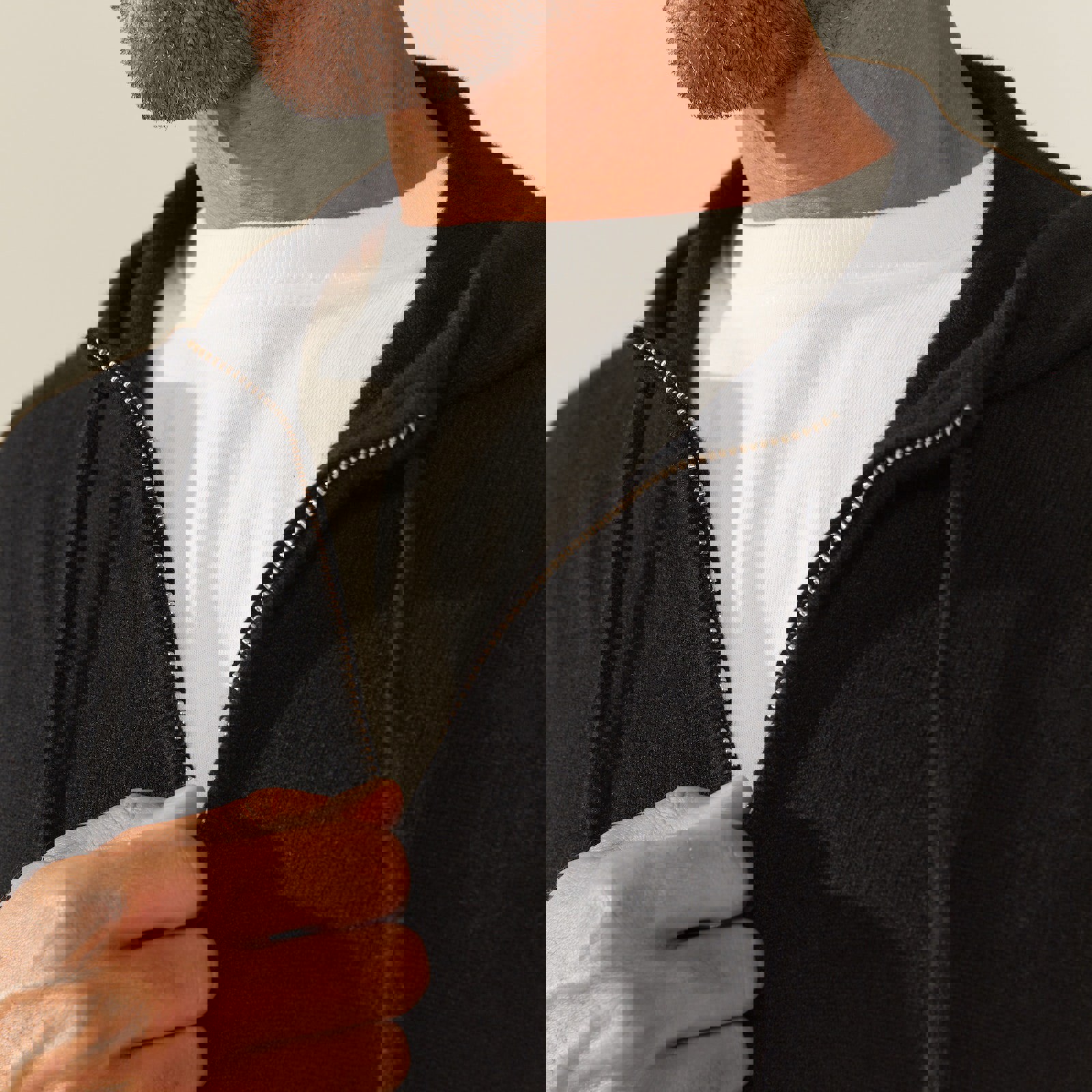 a man wearing a black hoodie and a white shirt