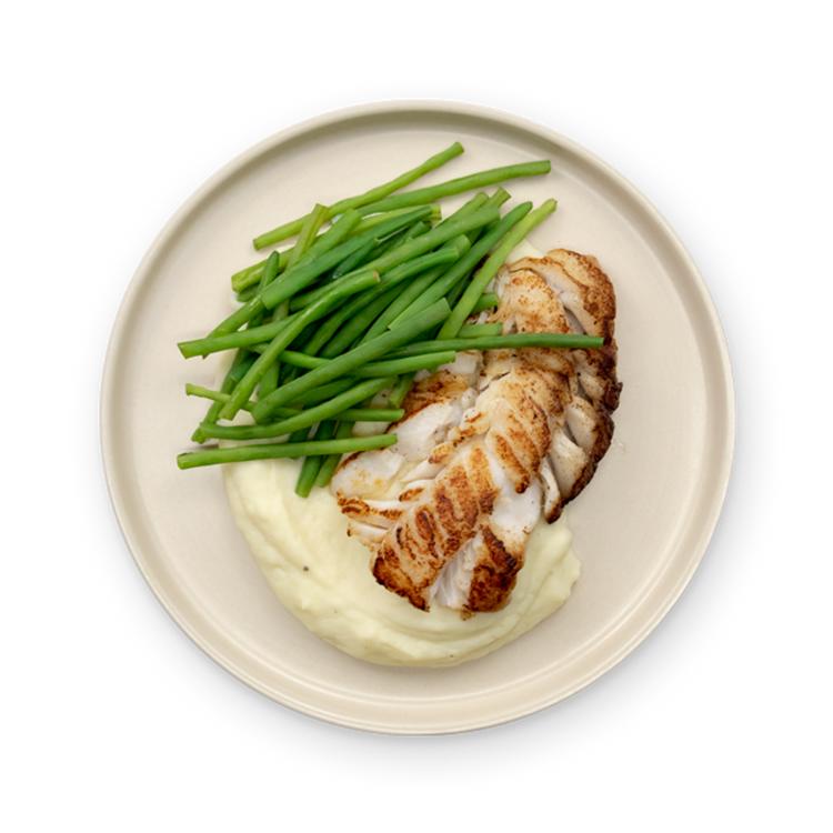 a plate of food with mashed potatoes and green beans on a white background